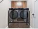 Modern laundry room features side-by-side washer and dryer units and overhead cabinet storage at 376 Dallas St, Denver, CO 80230