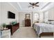 Tranquil bedroom features tray ceilings, a dresser, TV and an ensuite bathroom at 376 Dallas St, Denver, CO 80230