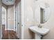 Stylish powder room with a pedestal sink, a round mirror, and modern fixtures at 376 Dallas St, Denver, CO 80230