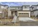 Two-story house with gray siding, stone accents, and a two-car garage at 17189 E 103Rd Pl, Commerce City, CO 80022