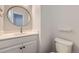 Compact powder room featuring a modern vanity, round mirror, and toilet at 17189 E 103Rd Pl, Commerce City, CO 80022