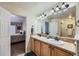 Bathroom with a double vanity and large mirror, with an adjoining bedroom adding natural light at 1104 Rumbling Sky Pl, Castle Rock, CO 80108