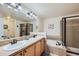 Bright bathroom featuring a double vanity, tub, and a glass-enclosed shower, providing comfort and style at 1104 Rumbling Sky Pl, Castle Rock, CO 80108