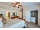 Bright bedroom featuring a ceiling fan, neutral paint, a wood dresser with mirror, and organized closet with storage at 1104 Rumbling Sky Pl, Castle Rock, CO 80108
