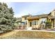 Charming exterior of a multi-level home with stone accents and a well-manicured lawn at 1104 Rumbling Sky Pl, Castle Rock, CO 80108