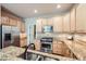 Modern kitchen featuring granite countertops, stainless steel appliances, and natural wood cabinetry at 1104 Rumbling Sky Pl, Castle Rock, CO 80108