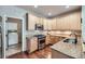 Well-lit kitchen with wooden cabinets, stainless steel appliances, and adjacent laundry room at 1104 Rumbling Sky Pl, Castle Rock, CO 80108