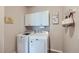 Functional laundry room featuring front-load washer and dryer, wall cabinets, and practical tile flooring at 1104 Rumbling Sky Pl, Castle Rock, CO 80108