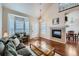 Bright living room with hardwood floors, a fireplace, and large bay windows at 1104 Rumbling Sky Pl, Castle Rock, CO 80108