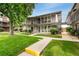 Attractive multi-level townhome featuring private balconies, lush landscaping, and a pedestrian walkway at 6495 E Happy Canyon Rd # 158, Denver, CO 80237