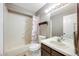 Neutral toned bathroom showcasing updated lighting, a single sink vanity, and combined tub and shower at 8827 Cloverleaf Cir, Parker, CO 80134