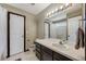 Neutral toned bathroom featuring a single sink vanity, updated lighting, and combined tub and shower at 8827 Cloverleaf Cir, Parker, CO 80134