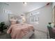 Bright bedroom with pink bedding and a window offering a view at 16130 E 111Th Dr, Commerce City, CO 80022