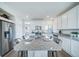 Modern kitchen with white cabinets, granite island, and stainless steel appliances at 16130 E 111Th Dr, Commerce City, CO 80022