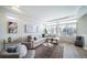 Open concept living room with large windows, L-shaped sofa and decorative pillows at 16130 E 111Th Dr, Commerce City, CO 80022