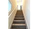 Carpeted staircase with handrail and safety gate at 7883 S Kalispell Cir, Englewood, CO 80112
