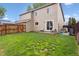 Spacious backyard with lush lawn, wood fence, and outdoor seating area at 21125 E 43Rd Ave, Denver, CO 80249