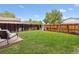 Well-maintained backyard with grass, a wooden fence, and a seating area at 21125 E 43Rd Ave, Denver, CO 80249