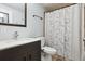 Well-lit bathroom with modern vanity, dark wood accents, and a shower with floral curtains at 21125 E 43Rd Ave, Denver, CO 80249
