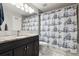 Updated bathroom featuring marble floors, a vanity with a black cabinet, and a shower with a ship-themed curtain at 21125 E 43Rd Ave, Denver, CO 80249
