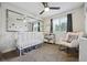 Charming Bedroom with a white crib, a rocking chair and natural light from the window at 21125 E 43Rd Ave, Denver, CO 80249