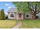 Charming home with well-maintained lawn, mature tree, and red front door at 21125 E 43Rd Ave, Denver, CO 80249