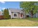 Charming home with well-maintained lawn, mature tree, and red front door at 21125 E 43Rd Ave, Denver, CO 80249