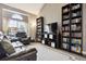 Cozy living room with large window, bookcases, and comfortable leather seating at 21125 E 43Rd Ave, Denver, CO 80249