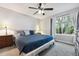 Bedroom features plush carpeting, a ceiling fan, and a bright window with a backyard view at 21125 E 43Rd Ave, Denver, CO 80249