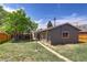 View of backyard showing a gray single-car garage, grassy lawn and access path at 3685 Jasmine St, Denver, CO 80207