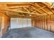 View of the empty one-car garage interior featuring exposed rafters and an automatic door opener at 3685 Jasmine St, Denver, CO 80207