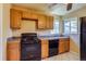 This kitchen features black appliances, a window, tile floors, and wood cabinets at 3685 Jasmine St, Denver, CO 80207