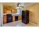 This kitchen features black appliances, a window, tile floors, and wood cabinets at 3685 Jasmine St, Denver, CO 80207