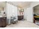 Bright primary bathroom with a chair, dual sink vanity, and lots of storage at 7018 E 123Rd Pl, Thornton, CO 80602
