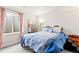 Cozy bedroom with a patterned bedspread, side table, and natural light at 7018 E 123Rd Pl, Thornton, CO 80602