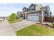 The gray two-story home features an attached two car garage, and a well-manicured lawn at 7018 E 123Rd Pl, Thornton, CO 80602