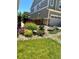Landscaped front yard with green lawn, trees, garage, and vibrant flower beds at 7018 E 123Rd Pl, Thornton, CO 80602