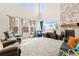 Spacious living room with tall windows, a cozy fireplace, and comfortable seating at 7018 E 123Rd Pl, Thornton, CO 80602