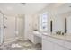 Bright bathroom featuring marble floors, a shower, and a dual-sink vanity at 39836 Floyd St, Elizabeth, CO 80107