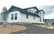 Side view of a modern white house with dark trim and gravel landscaping at 39836 Floyd St, Elizabeth, CO 80107