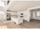 Modern white kitchen with large island, stainless steel appliances, and hardwood floors at 39836 Floyd St, Elizabeth, CO 80107