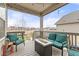 Relaxing covered back porch with cushioned seating, a gas fire pit, and string lights at 17614 Drake St, Broomfield, CO 80023