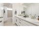 Bright bathroom with double vanity, white cabinets and framed mirror and a shower-tub combo at 17614 Drake St, Broomfield, CO 80023