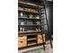 Stylish black bookshelf with rustic wooden shelves and drawers, complemented by a decorative ladder at 17614 Drake St, Broomfield, CO 80023