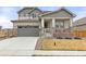 Charming two-story home with a gray exterior, stone accents, a well-kept lawn and a welcoming front porch at 17614 Drake St, Broomfield, CO 80023