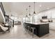 Modern kitchen with white cabinets, a dark island with bar stools, and an open layout into the living room at 17614 Drake St, Broomfield, CO 80023