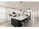 Modern kitchen featuring white cabinets, stainless steel appliances, a large island, and stylish pendant lighting at 17614 Drake St, Broomfield, CO 80023