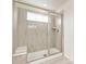 Modern shower showcasing stylish tiling, glass doors, and convenient bench seating at 17614 Drake St, Broomfield, CO 80023