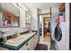 Bathroom featuring a vanity with tiled countertop and sink, in close proximity to laundry area at 9508 Lou Dr, Northglenn, CO 80260