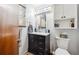 Bathroom featuring a dark vanity with marble top, sink, and upper storage cabinet at 9508 Lou Dr, Northglenn, CO 80260